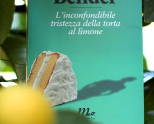Copertina dell'articolo sul empatia e scrittura; l'immagine mostra il libro L'inconfondibile tristezza della torta al limone tra le foglie di un albero di limoni.